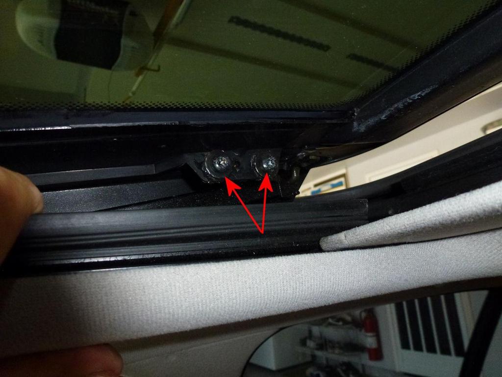 Step 4: Press the gators down and you will be able to see the two Torx 25 screws on each side of the rear of the sunroof (see Figures 8 and 9). Remove those.