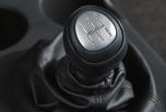 To shift into reverse, lift up on the reverse-lockout collar located under the shift knob and move the lever into the gate marked R. See Section 2 of your Owner Manual.