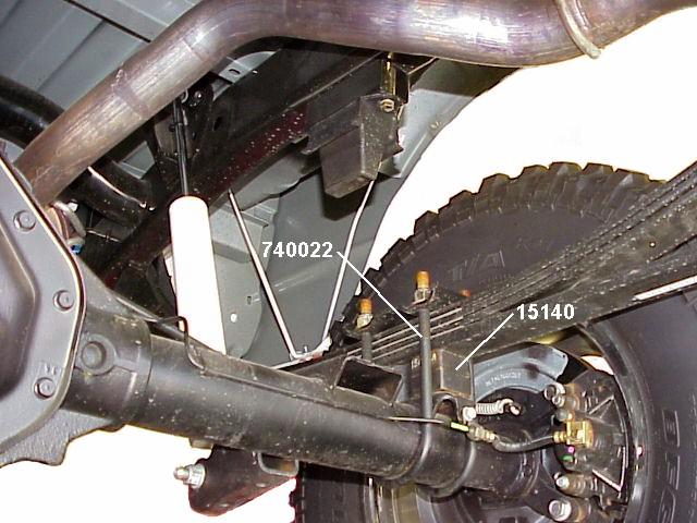 Tighten bolt to 30 ft. lbs. 3) Carefully lower the axle about four inches. Do not allow the axle to hang by any hoses or cables. 4) Insert a block pin from kit 860407 into the hole in the axle pad.