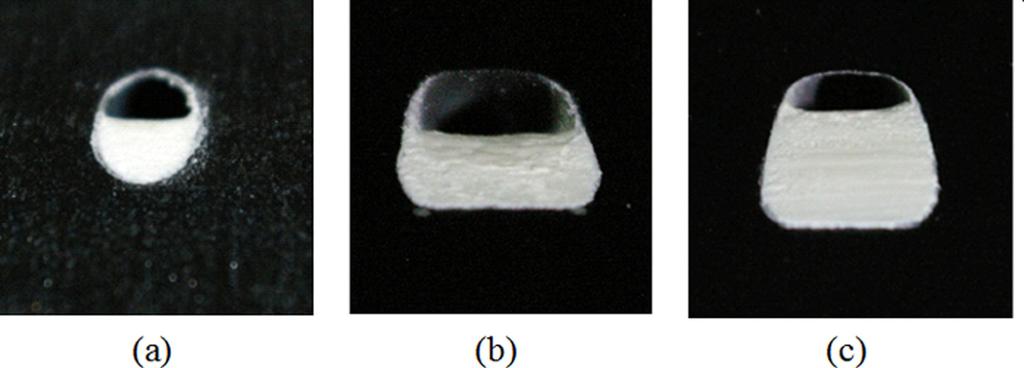Fig. 4 Axial photographs of the blocked hole exits of (a) a cylindrical hole with a t/d 5 0.5 blockage, (b) a shaped hole with a t/d 5 0.5 blockage, and (c) a shaped hole with a t/d 5 0.