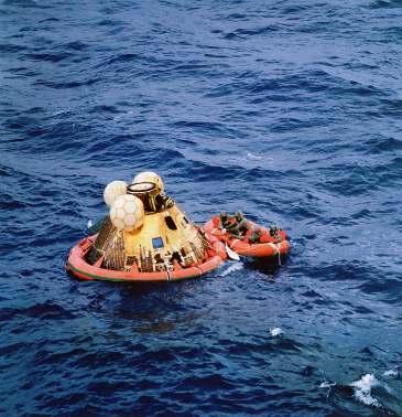 Photo #15: Apollo 11 Block II Command Module post-splashdown with uprighting bags inflated and flotation collar installed.