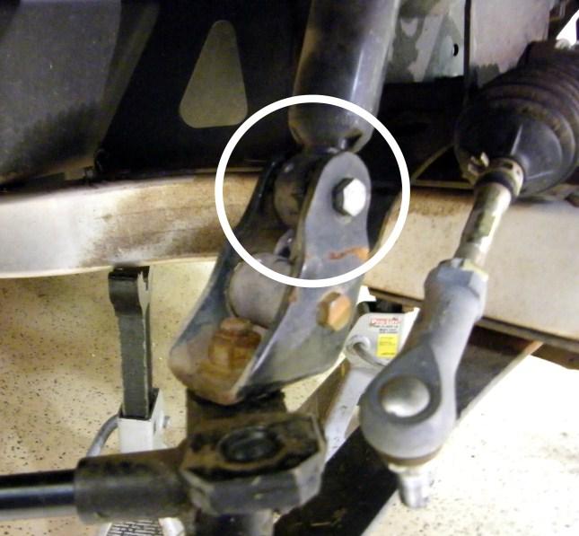 11. Disconnect the shocks from the top clevis by removing the bolt on
