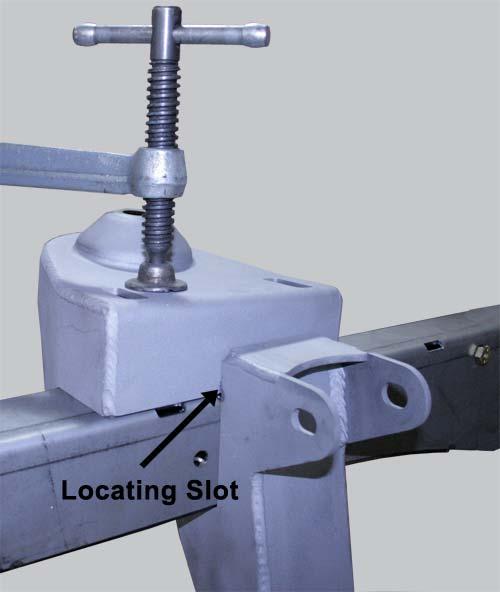 Using a C-clamp and pull the bracket down snug to the top of the frame rail keeping the locating slot aligned with the front edge of the cross member and the outside