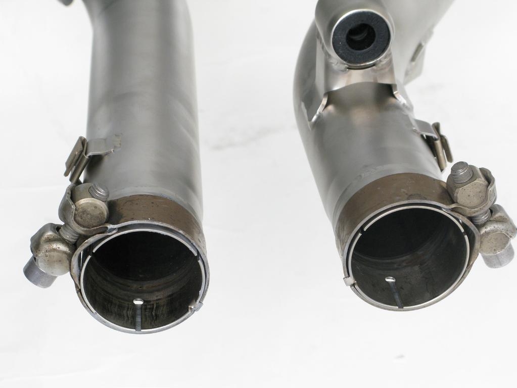 INSTALLATION OF THE AKRAPOVIČ EXHAUST SYSTEM: 1. Install the original clamps and heat shields spring clips onto the Akrapovič muffler pipes, as shown (Figure 7).