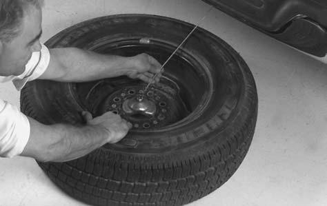 3. Pull the wheel toward the rear of the vehicle, keeping the cable tight. 4. Attach the ratchet, with the UP side facing you, to the wheel wrench. 5.