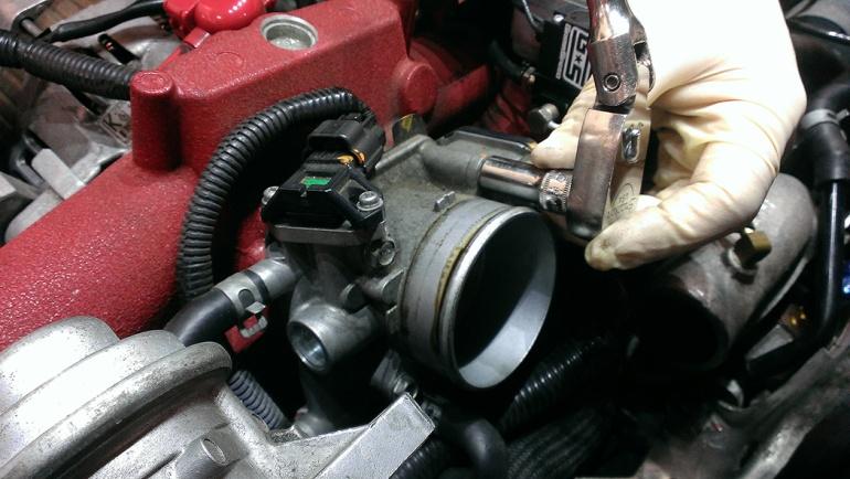 Using a 10mm socket, remove the 4 bolts that secure the throttle body to the