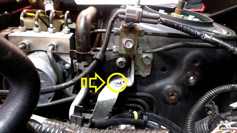 Using a 10mm socket, remove the bolt that holds the power steering