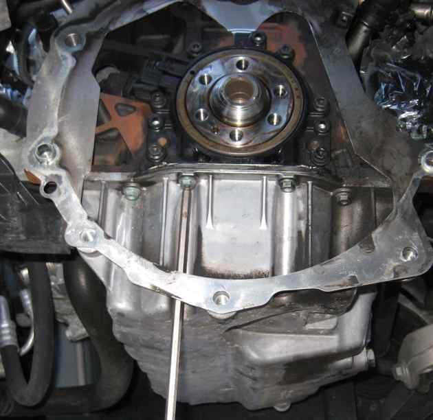 using extensions and a u-joint. Gently pull the seal flange straight off. Don't pry close to the sealing surfaces of the crankshaft or you might scratch it.