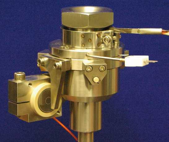 The various fixed specimen test adapters may be mounted on a mandrel projecting through the bottom of the chamber and coaxial with test spindle.
