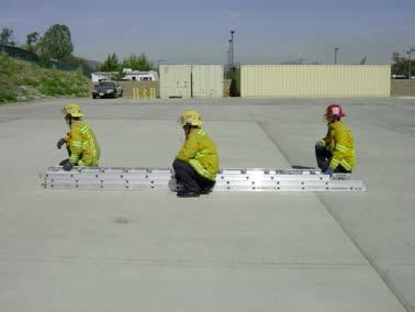 The second firefighter will position at the tip end of the ladder between the first and second rung facing the tip end of the ladder.