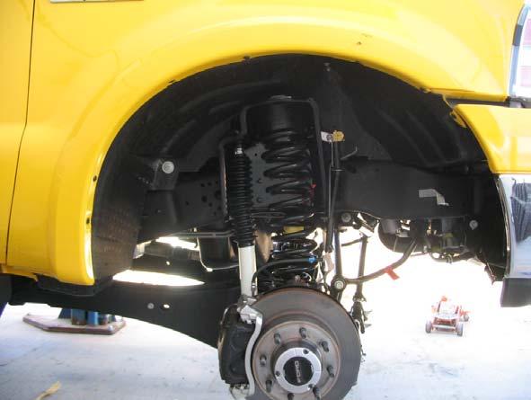 support the axle so it can be lifted and lowered relative to the vehicle. 4. Remove front wheels. 5.