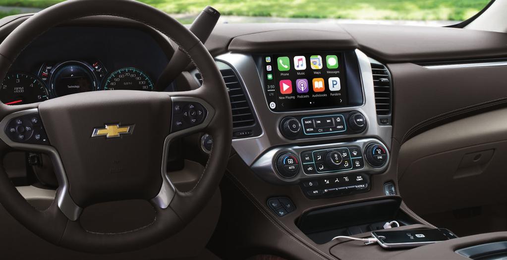 TECHNOLOGY Suburban Premier interior in Cocoa/Dune with available features. Apple CarPlay COMPATIBILITY. 1 MAINTAIN YOUR CONNECTIONS. SIRIUSXM SATELLITE RADIO.