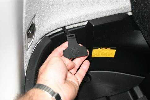 If the fuel filler door is inoperative due to a discharged battery or other trouble, there is an override pull cable inside the auxiliary box in the left side of the