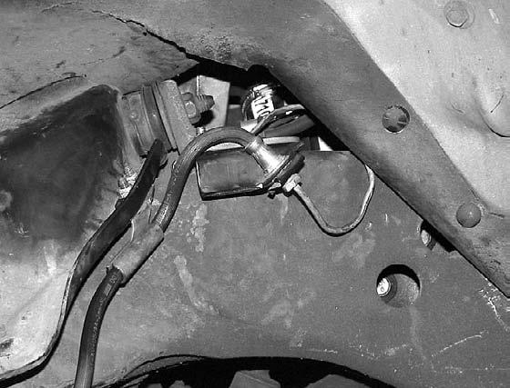Remove the bolt securing the brake line mount to the top of the frame