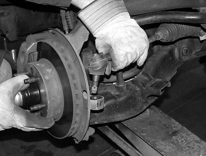 Support the lower control arm with a floor jack, using enough tension to compress the control arm ¼.