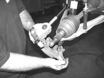 Disconnect the upper and lower ball joints from the steering knuckle by striking the knuckle with a large hammer next to each ball joint on the knuckle to dislodge the ball joints.