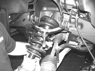 Unplug the ABS brake connection from the frame and control arm. Remove the brake hose bracket from the steering knuckle. Remove the brake hose bracket from the coil bucket and save hardware.