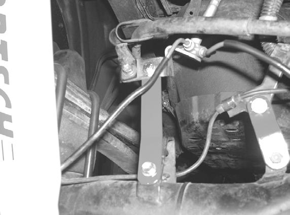 Remove the rear fuel tank bracket bolt and move emergency brake cable outside of bracket. Flip emergency brake cable bracket upside down and reattach with factory hardware. Reattach fuel tank bracket.