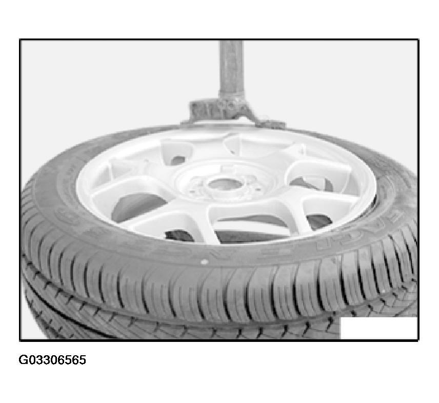Fig. 28: View Of Clamping Claws On Tire Bead MOUNTING 36 13 001 REPLACING A WHEEL TRIM Steel Wheels: Insert plastic tip of wheel bolt wrench (1) between wheel trim and