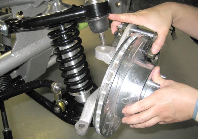 15. Installing Top A-Arm Ball Joint in Spindle. Position the spindle assembly under the upper a-arm ball joint and install. Install the thick stud washer and castle nut and torque 90-100 foot lbs.