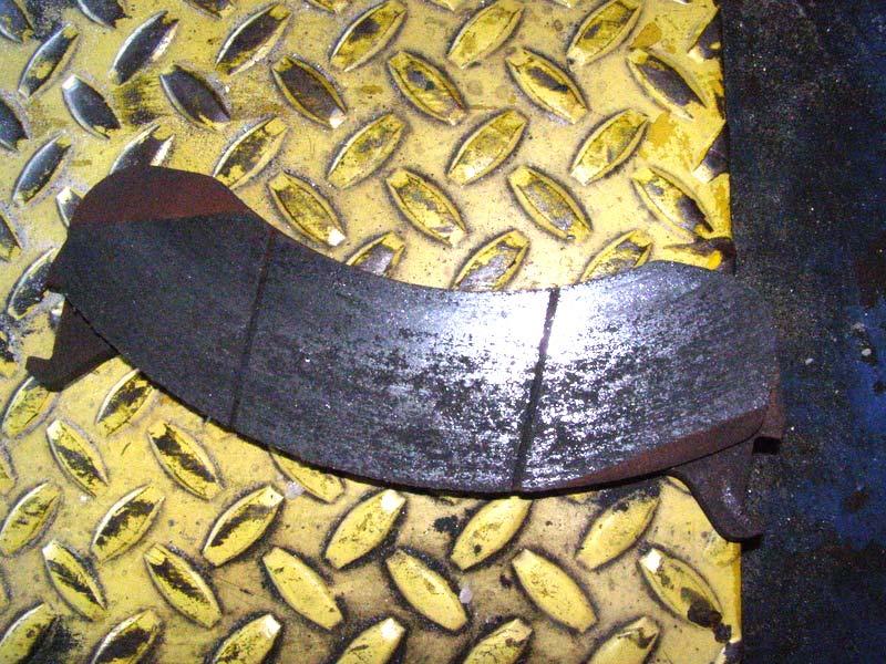 No repair action is required. The brake pad shown below exhibits the rough/damaged surface typically associated with material transfer from the pad to the rotor due to excessive heat.