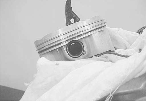 Place a clean rag over the cylinder base to prevent the piston pin circlip from dropping into the crankcase, and then fit the