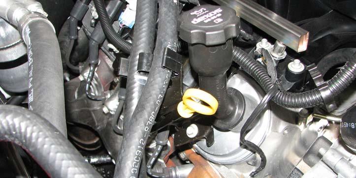 26. Using a 10mm socket, remove the bracket securing the heater hoses