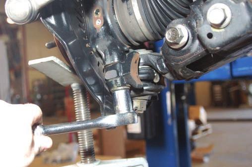 (4WD Model) Using a 22mm wrench remove the 2 lower ball joint bolts as shown in Photo 9. Remove knuckle from vehicle.
