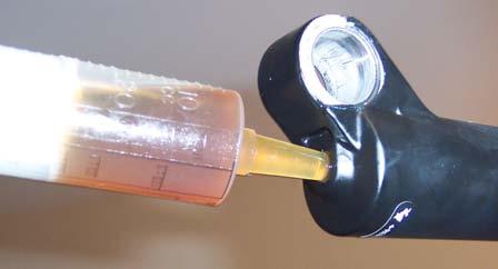 Use a plastic extension tube to draw the oil out of the bottle. Then, remove the tube to inject the oil.
