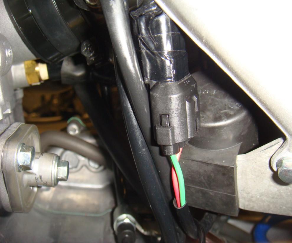 7. Locate the capacitor, a black two pin with one red wire and one green wire near the