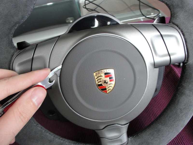 Step 2 Use the pocket knife to gentle pry open the Grey lid with Porsche logo on top of the wheel. Be really gentle as this is an operation which can have devastating effects to the look of the wheel.