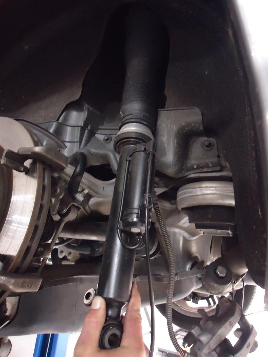 15. PULL DOWN ON THE LOWER CONTROL ARM AND REMOVE THE AIR STRUT FROM THE VEHICLE.