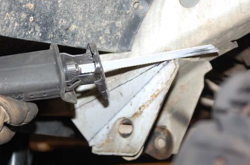 11. Using a reciprocating saw, cut the stock lower control arm mounts even with the frame. See Photo 5. 12.