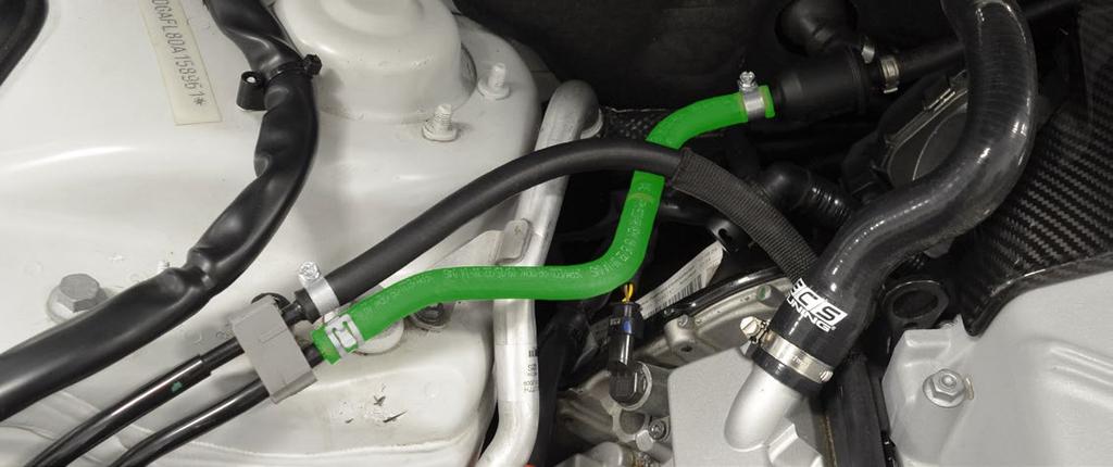 The clamp nearest the strut tower is a squeeze type clamp and can be easily removed with a pair of pliers. Remove the hose, flip it around, and orient it as shown (highlighted in GREEN in Fig: 1.2).