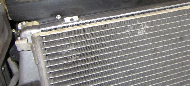 side (Outlet). Lift the intercooler and position the tabs in the radiator slots. 22.