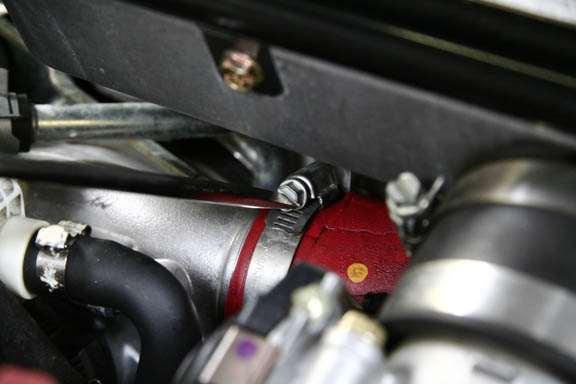 Unscrew the clamp that holds the red intercooler hose to the