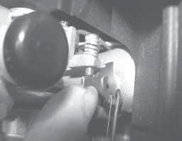 Hold the governor lever away from the carburetor, or hold the thro le lever so it is tight against the idle speed adjusting screw, to negate the governor activation. See Figure 19.