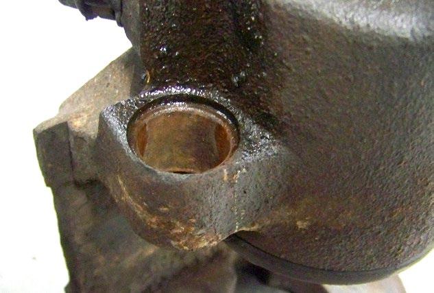 Note how much rust has accumulated between the bushing and the caliper (arrow).