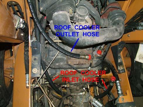 Route the longer inlet hose under the skid steer main hydraulic