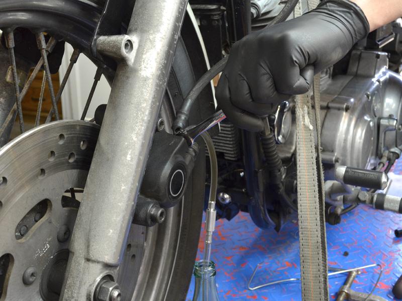 Continue to force more brake fluid out of the brake lines by depressing the front brake lever with your right