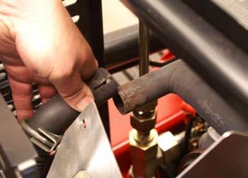 Using a 1/2 socket, loosen the two nuts securing the muffler clamp to the