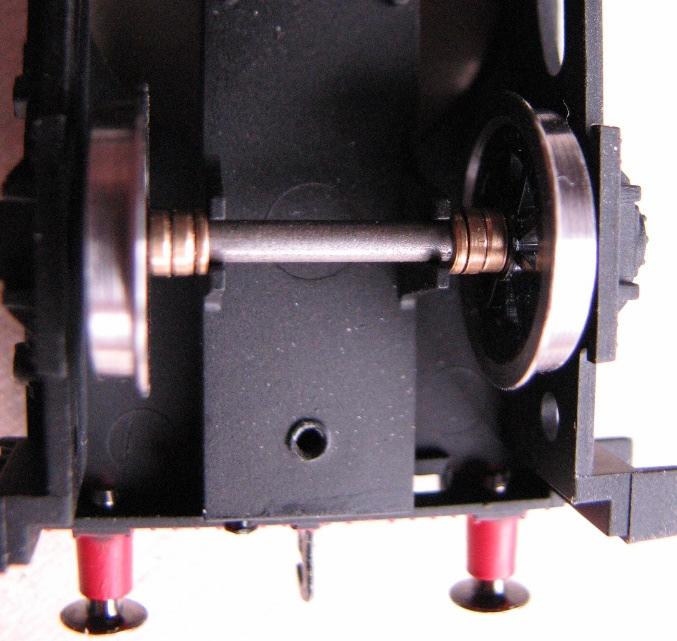Enlarged view showing spacers on installed Gibson wheel set. 5. Place wheel sets into the chassis. All 3 axles in place. 6. Replace the keeper plate and screws.