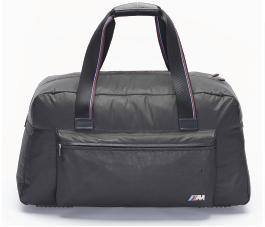 M TRAVEL BAG. Robust, stain-resistant and light thanks to special combination of materials. With large, attached exterior pocket. Lockable compartment for smaller items. Contrasting red seam on zips.