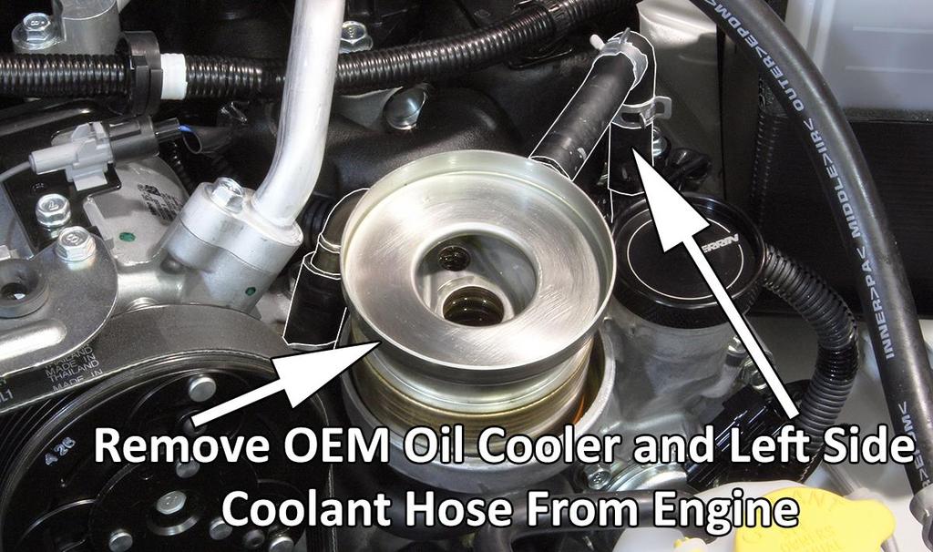 6. These next few steps should be done quickly to reduce the amount of coolant lost. a. Prepare to bypass OEM oil cooler and catch some amount of coolant. You will reuse three OEM pinch clamps. b. Locate left coolant hose (shown above) and disconnect from OEM metal pipe going into engine, NOT the OEM oil cooler.