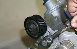 75. Remove the stock belt tensioner assembly by removing the two