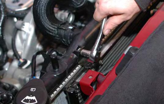 77. Remove the radiator retaining bracket on each side by