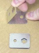 2. Fold the nut retainers in half along the perforated line. Leave the nut retainer slightly spread apart. 6.