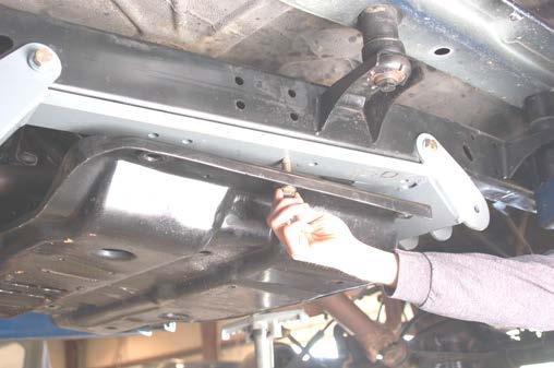 Using the new bracket as a guide, drill using a 17/32 drill bit through the inner and outer frame rail. See Photo 11.