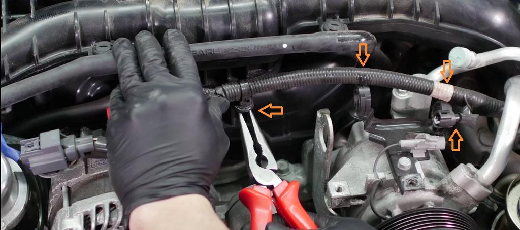 Disconnect the alternator cable from the intake manifold by compressing the tabs on the clip and