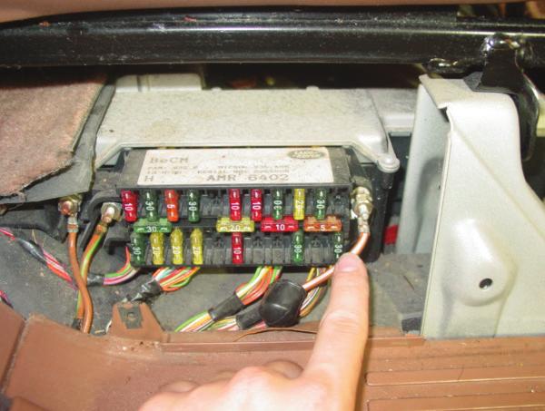 4. LOCATE THE POSITIVE BATTERY FEED TO THE RIGHT OF THE FUSE BOX (IT